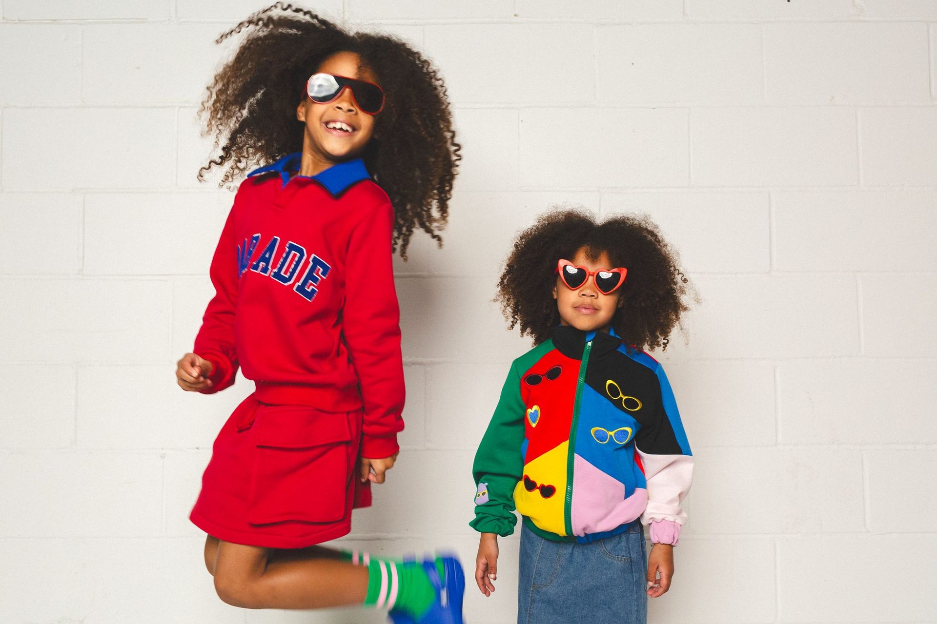 Two children in red Parade sweatshirts and a colour-block jacket