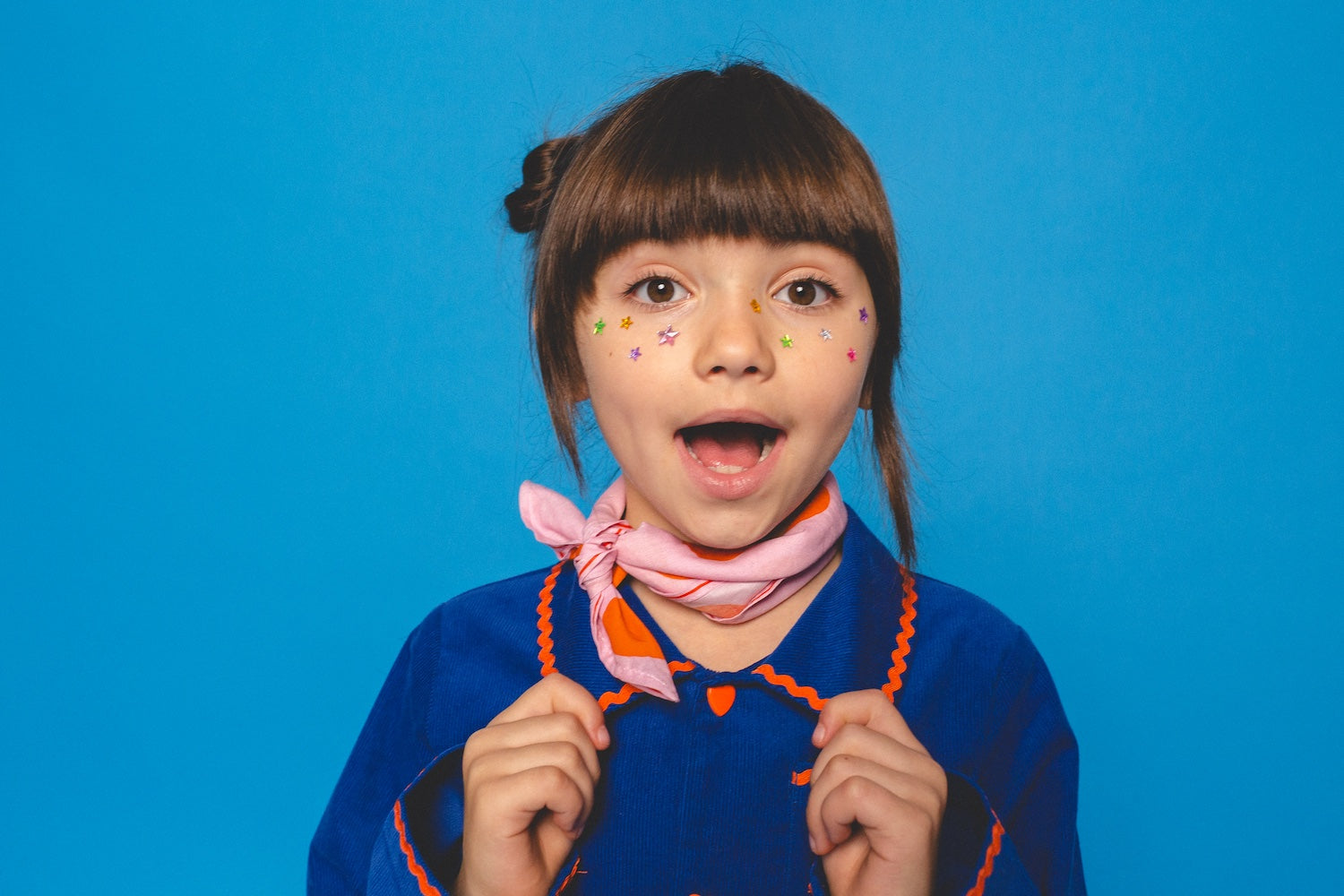 Girl with star stickers in a blue Hippo Parade jacket